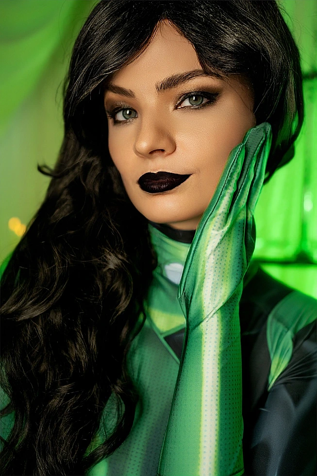 Shego cosplay close-up, green glove on cheek, dark lipstick, soft emerald light