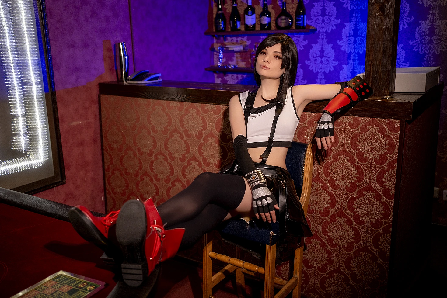 Tifa Lockhart cosplay 7th Heaven bar lounge, reclined chair pose, muscular legs, FF7 costume, thigh-high stockings, red boots, moody bar lighting