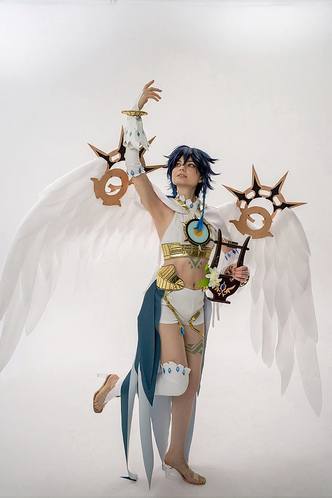 Venti cosplay from Genshin Impact stands with one arm raised, a lyre in the other hand and white wings spread.