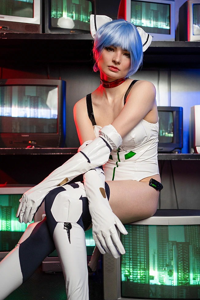 Rei Ayanami cosplay seated on a CRT TV with long white gloves folded over one raised knee